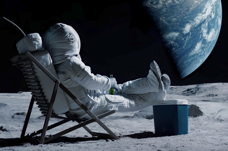 An astronaut sitting on the Moon in a lawn chair